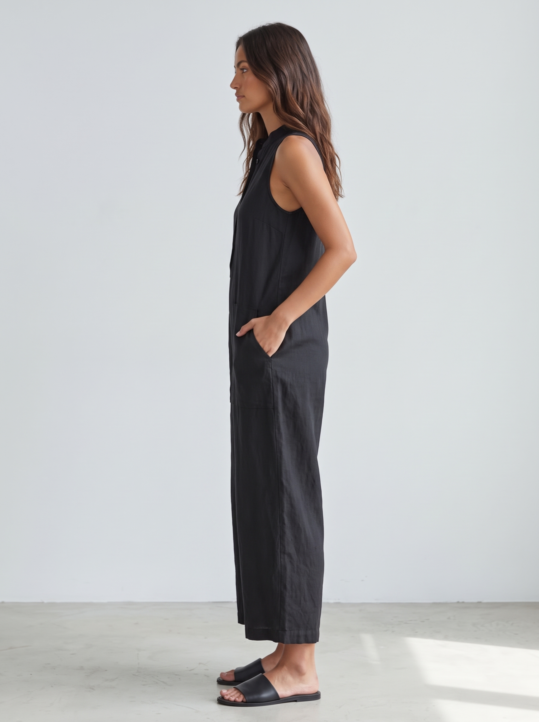 Black linen jumpsuit side view showing wide cropped legs